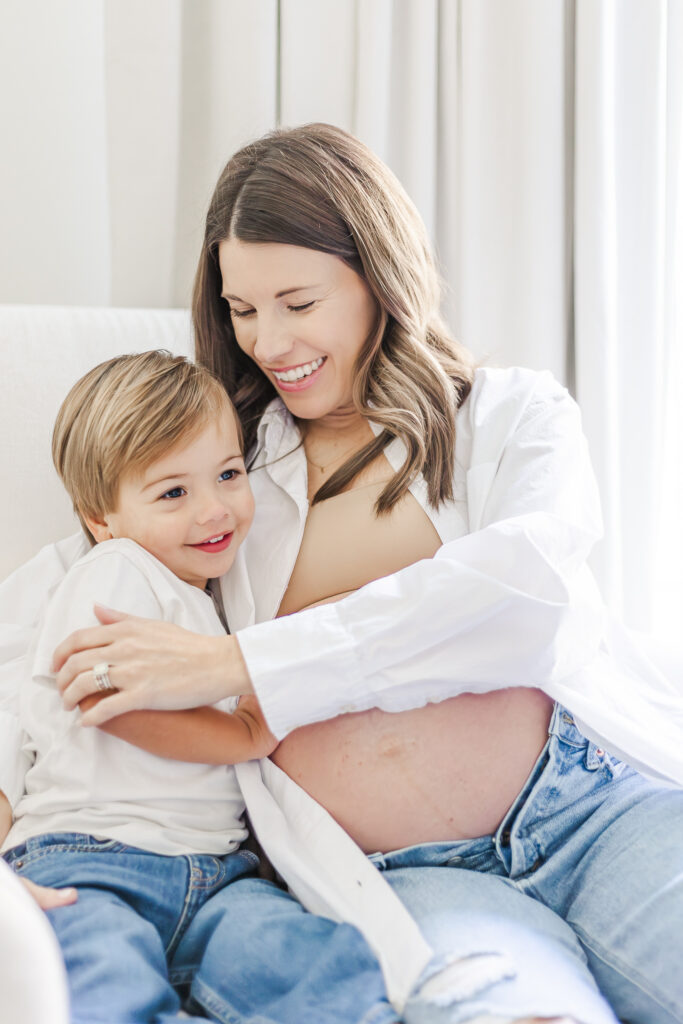 Expecting mom smiling down at her son during maternity session with 5U Photography in their home in Birmingham, AL