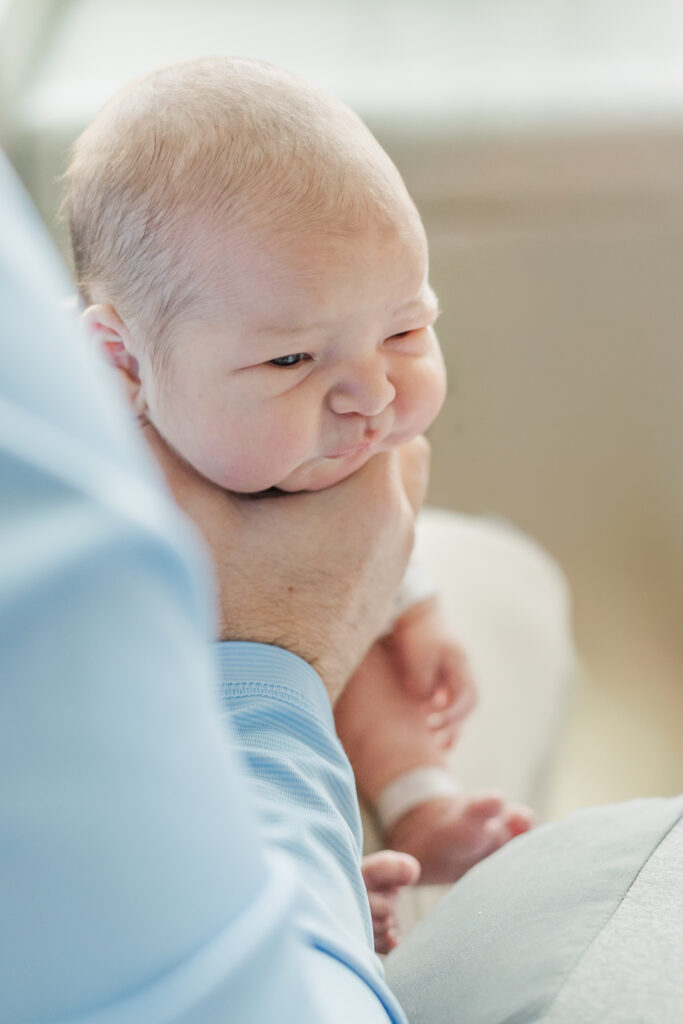 Dad holding newborn baby boy burping him after feeding during fresh-48 as the 1st milestone membership session with 5U Photography at Grandview Medical Center