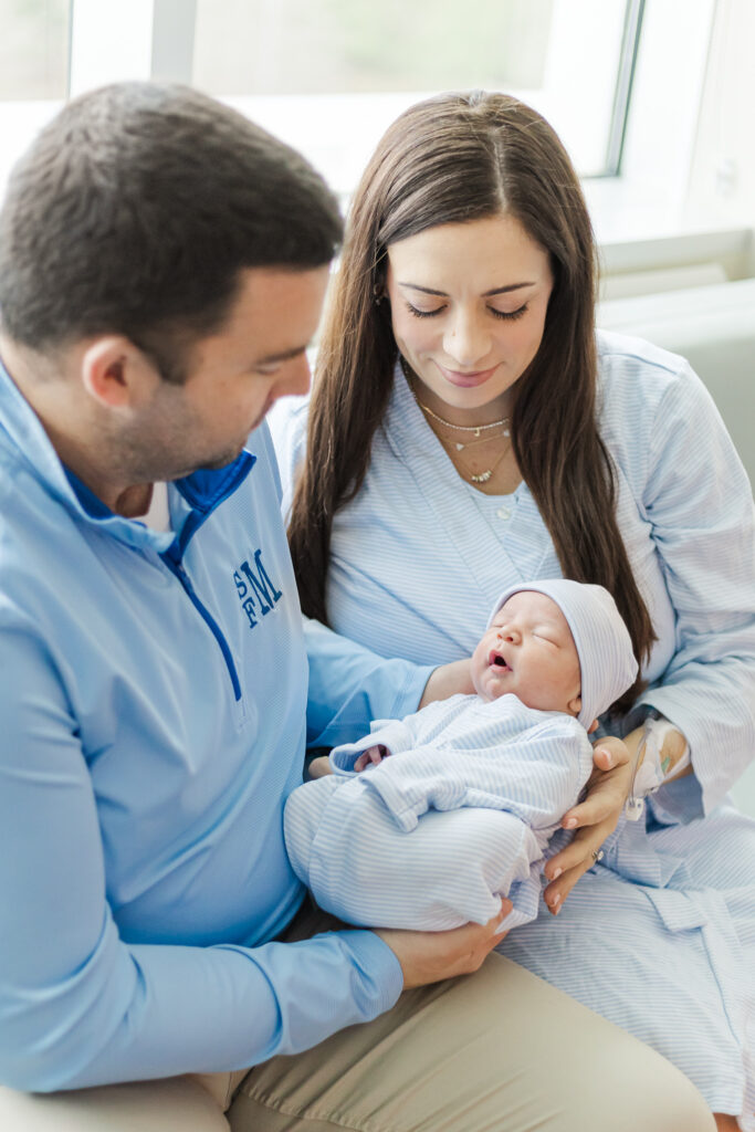 Mom and dad looking down lovingly at newborn baby boy during in-hospital session at Grandview medical center in birmingham AL