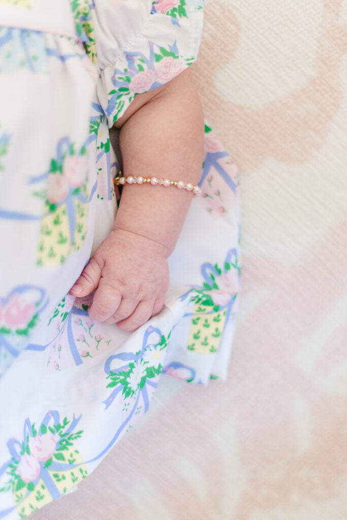 close up of little girls arm wearing delicate pearl bracelet 