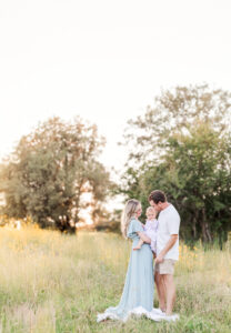 Parents and children photographed together in dusty blue and blush pink outfits with layered knits and bows, styled for autumn portraits
