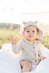Little Girl sitting in hooded cable knit sweater looking at camera during fall session with 5U Photography