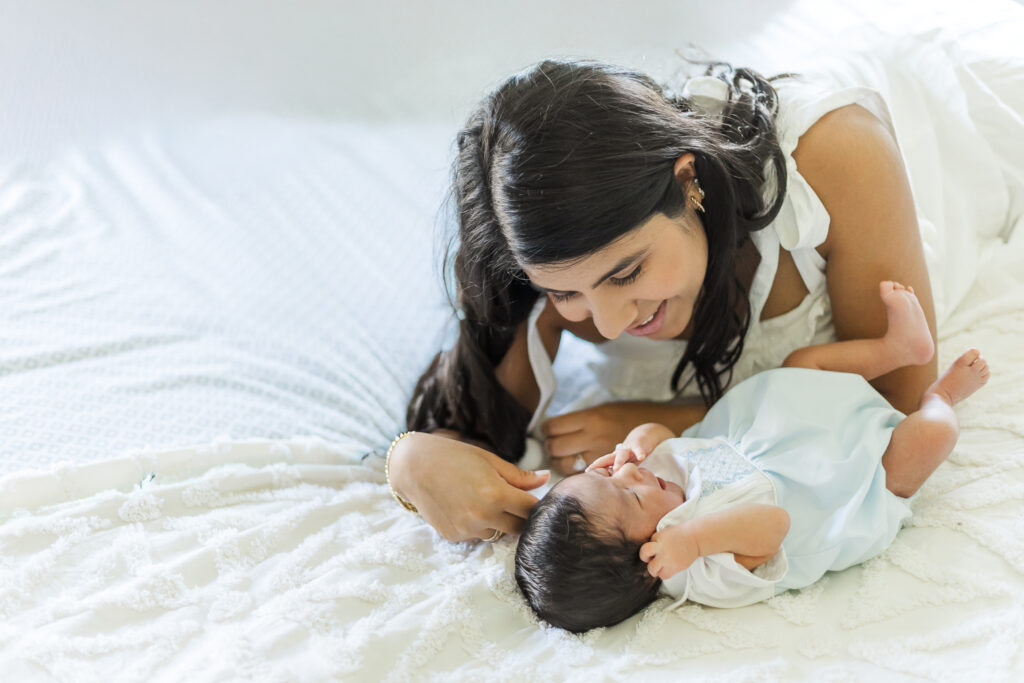 Mother smiling at newborn baby boy during a cozy in-home newborn lifestyle session in Trussville, Alabama captured by 5U Photography.